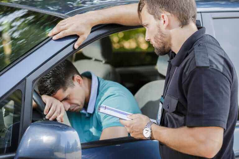 A man in a car being given a speeding fine