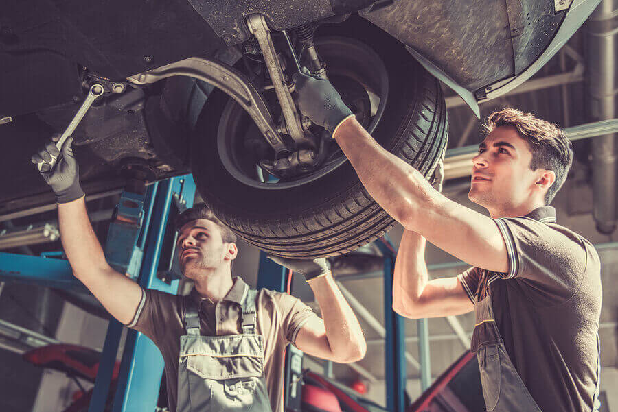 2 Mechanics working on a car which is on a ramp